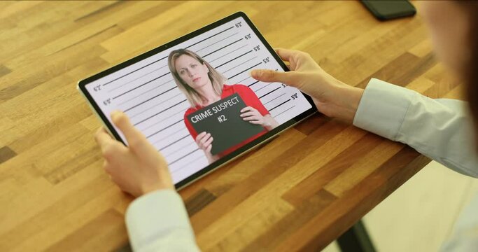 Witness to crime flips through photo on tablet of suspects in crimes. Rights and obligations of suspect and search for offender