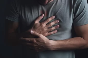 Papier Peint photo Vielles portes A man with heart pain in his chest, keeps his hands on his chest.