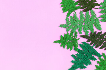 Crocheted green fern leaves on a lilac background. Summer banner. Flat lay, copy space