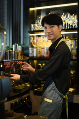 Smiling male barista preparing coffee for customer order in trendy coffee. Small business concept.