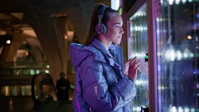 Woman choosing food automat standing in subway close up. Girl buying snacks.