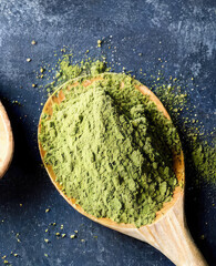 Moringa powder trendy superfood supplement. Green powder in wooden spoon. Matcha for making drinks.