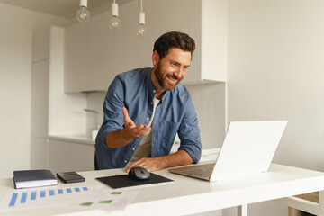 Naklejka premium Male freelancer have a video conference from laptop during distance work from home kitchen