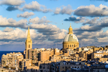 City view of Valletta just before sunset. Historical buildings and old town with sea and clouds