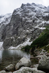 Czarny Staw pod Rysamy or Black Pond lake near the Morskie Oko Snowy Mountain Hut in Polish Tatry mountains, drone view, Zakopane, Poland. Aerial view shot of beautiful green hills and mountains in