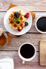 Belgian waffles with berries. Morning. On a wooden background