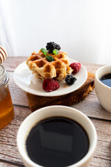 Belgian waffles with berries. Morning. On a wooden background