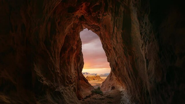 Cinemagraph seamless loop of moving sunset cloud sky time lapse at a cave in famous Wadi Rum Bedouin desert, UNESCO heritage landscape, Jordan. Lawrence of Arabia filming location and tourist travel.
