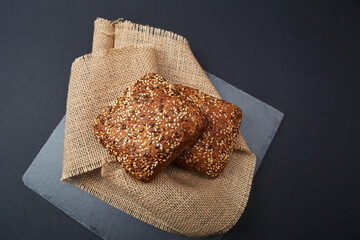 Two freshly baked rustic square shaped bread loaves with sesame seeds on the vintage rustic country...