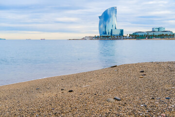 Obraz premium San Miguel beach in Barcelona overlooking the promenade and the W-hotel in the form of a sail. Wide strip of sand