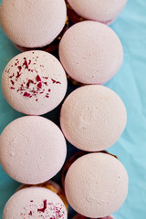 Assorted sweet french pink macarons on blue background
