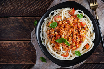 Spaghetti pasta and tomato sauce with chicken mince on a wooden background. Pasta bolognese. Top view