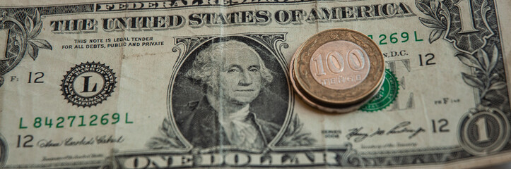 Kazakhstan coins on one American dollar. 100 Kazakhstan tenge coins.