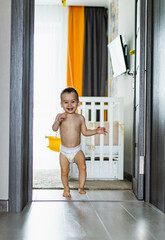 Cute baby standing in a doorway wearing a diaper. A baby in a diaper standing in a doorway