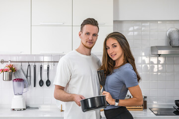 Caucasian young couple in white kitchen cooking making preparing healthy food.