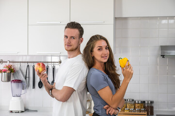 Caucasian young couple in white kitchen cooking making preparing healthy food with vegetables.