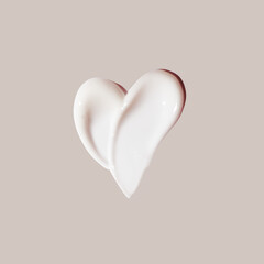 cosmetic smear of cream in the shape of heart on beige background - 630687340