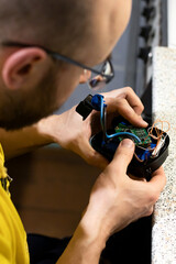 Fototapeta na wymiar Adult man repairing a battery charger. Working with electronic devices and microelectronics