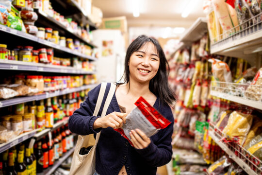 20-something Asian woman shopping buying groceries at a supermarket