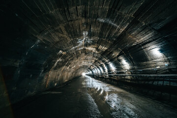 Long concrete underground industrial tunnel or corridor.