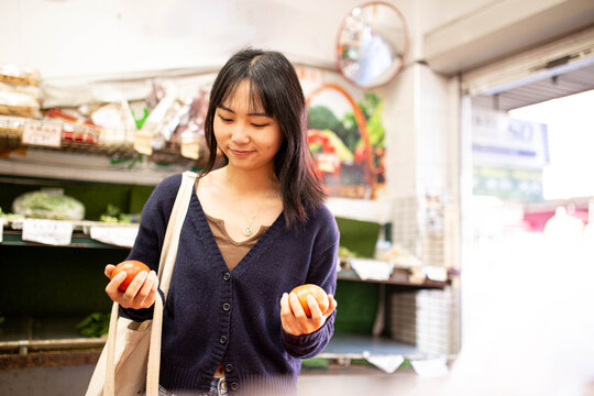 20-something Asian woman shopping buying groceries at a supermarket