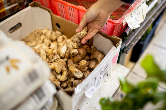 Picking up ginger root while buying groceries at a supermarket