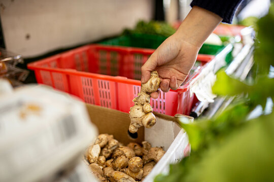 Picking up ginger root while buying groceries at a supermarket
