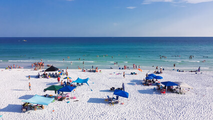 Colorful beach umbrella and people swimming, laid-back relaxing on sugar-white sand beaches, crystal clear clean gorgeous shade of blue turquoise water Destin, South Walton, Florida, USA