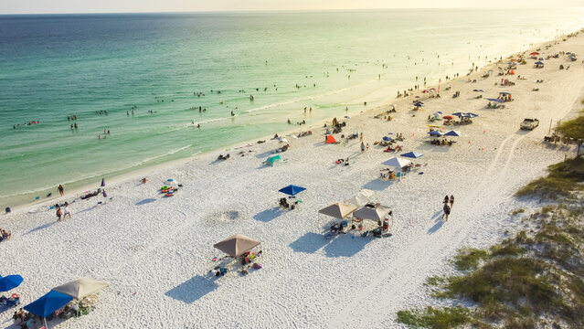 Miles of sugar-white sandy beaches with clear turquoise water, gorgeous shade blue waves near Miramar Beach east South Walton, Destin, Florida, USA crowed people relaxing, swimming, laid-back