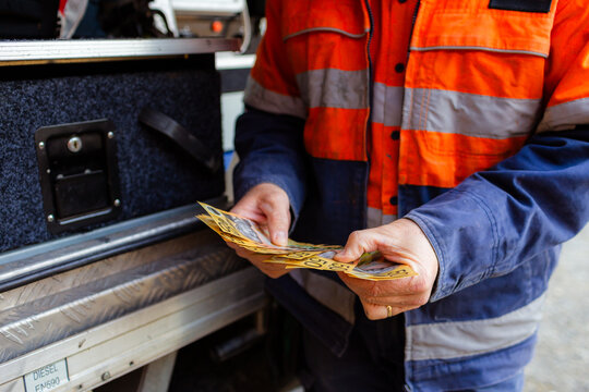 Male tradie counting cash payment for job paid in cash