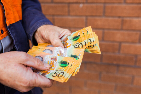 Handyman holding bank notes counting cash received as payment for job completion