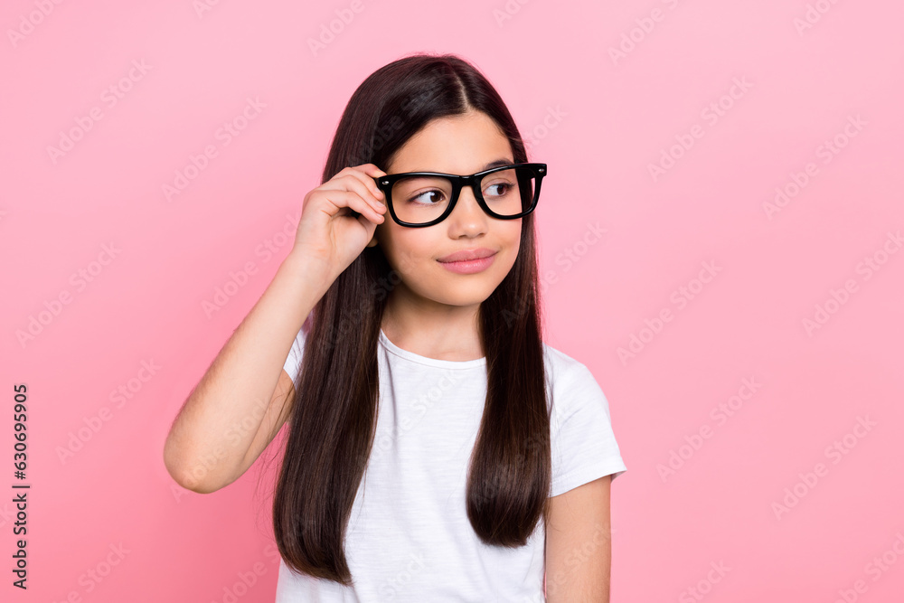 Wall mural Photo portrait of adorable schoolkid female touch specs look empty space promo wear trendy white outfit isolated on pink color background