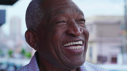 One joyful black senior man close-up face smiling at sky with friendly charismatic expression