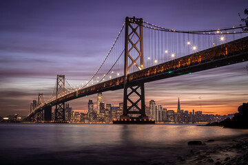 San Francisco-Oakland Bay Bridge and city skyline at sunset in California, USA