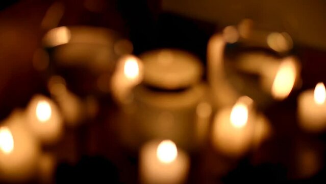 Wine splashes in glasses, candles burn in the dark. The blurred image becomes clear. The focus shifts to wine glasses. Background video for a romantic evening.