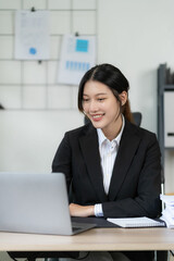 Asian woman working in office with laptop Asian business woman accountant Information documents sitting at his office. vertical image