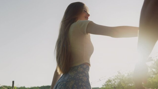Young affectionate couple holding hands walking outdoors at sunset. People lifestyle concept. Valentine day. Romantic concept. Love concept.