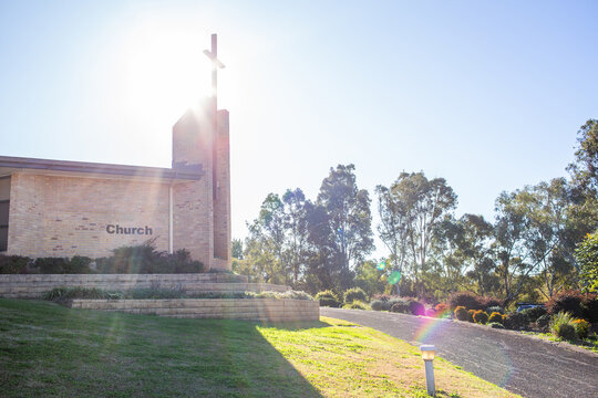 Light flare though cross on modern church building