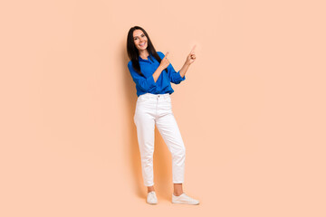 Full length photo of cheerful lady wear trendy smart casual outfit two arms demonstrate empty space isolated on beige color background