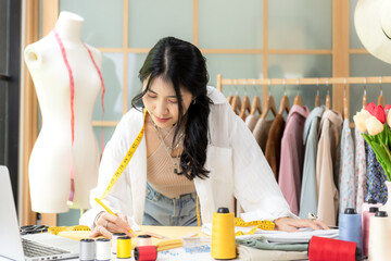 Asian young women fashion designer  working on her designer in the showroom,  Lifestyle Stylish...