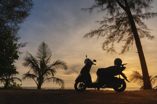 Motorbike and palm trees on the background of a colorful sunset in Thailand. Tourism and vacations, holidays at resorts by the sea. relax picture carefree vacation