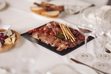 Catering service. Restaurant table with food. Huge amount of food on the table. Plates of food. Dinner time, lunch. Appetizers table with different antipasti, charcuterie, snacks, cheese, salad, pate.