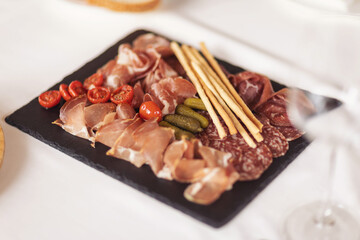 Catering service. Restaurant table with food. Huge amount of food on the table. Plates of food. Dinner time, lunch. Appetizers table with different antipasti, charcuterie, snacks, cheese, salad, pate.