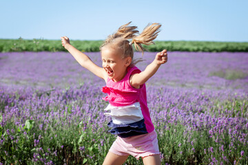 Happy Summer Holiday on Nature. Happy Child Little Girl Having Fun Jumping in Lavender Field. Have...