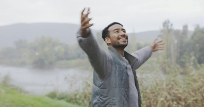 Travel, open arms or happy man by lake in nature for peace walking, hiking or trekking in mountain forest. Relax, calm or zen hiker breathing by river adventure with on camp, gratitude or freedom