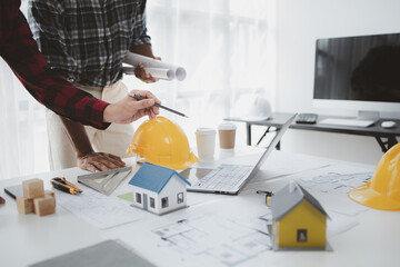 The home design architects are reviewing the house plan draft, the project commissioned by the client, and the custom design before delivery. Interior design and decoration ideas.