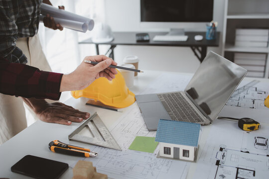 The home design architects are reviewing the house plan draft, the project commissioned by the client, and the custom design before delivery. Interior design and decoration ideas.