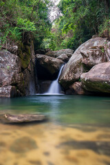 Naklejka na ściany i meble Tranquil Scene of a Small Silky Waterfall in a Tropical Rainforest