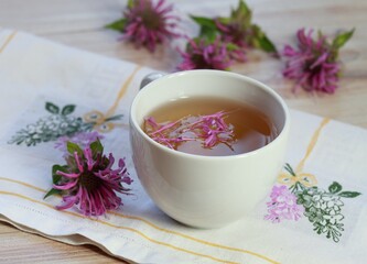 Herbal tea from Monarda didyma, also called bergamot or beebalm. Sweet smelling tea with bergamot aroma, often used as medicinal herb on embroidered napkin.