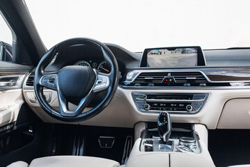 Obraz premium Expensive car interior with steering wheel, multimedia dashboard and gearbox handle. 